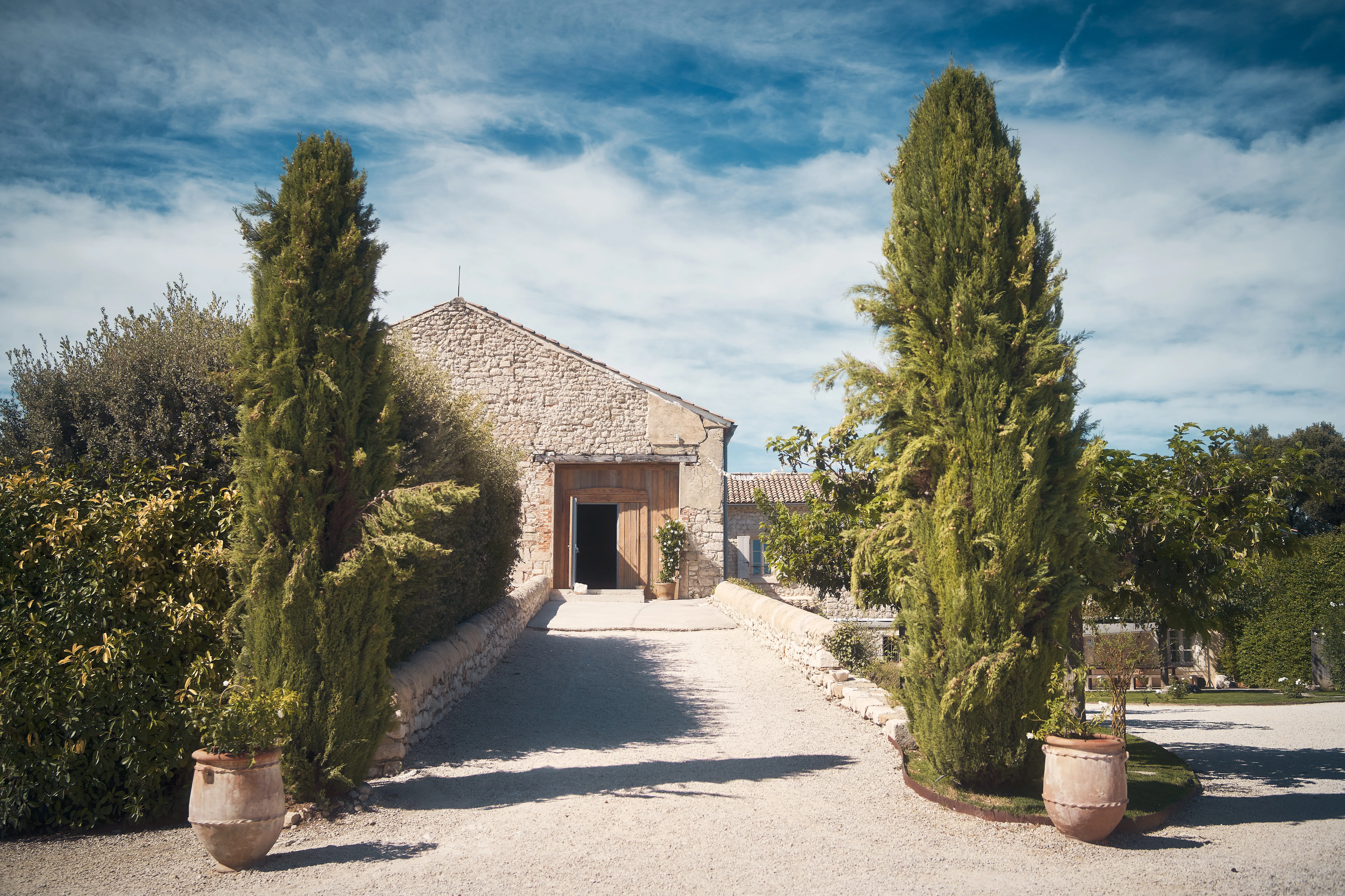 Jardin aménagé autour d'une demeure en pierre.
