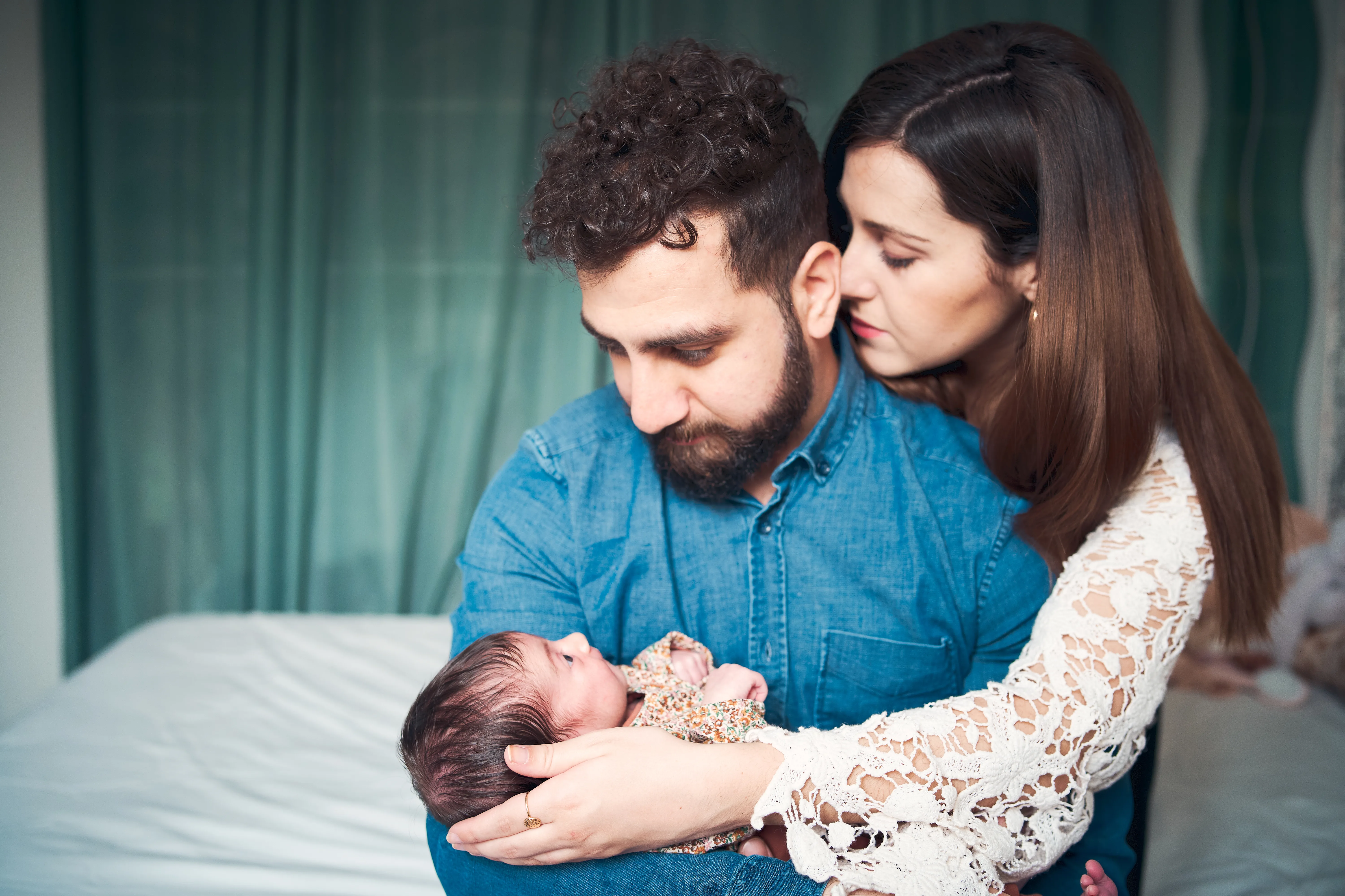 Parents regardant leur nouveau-né allongé sur le lit.