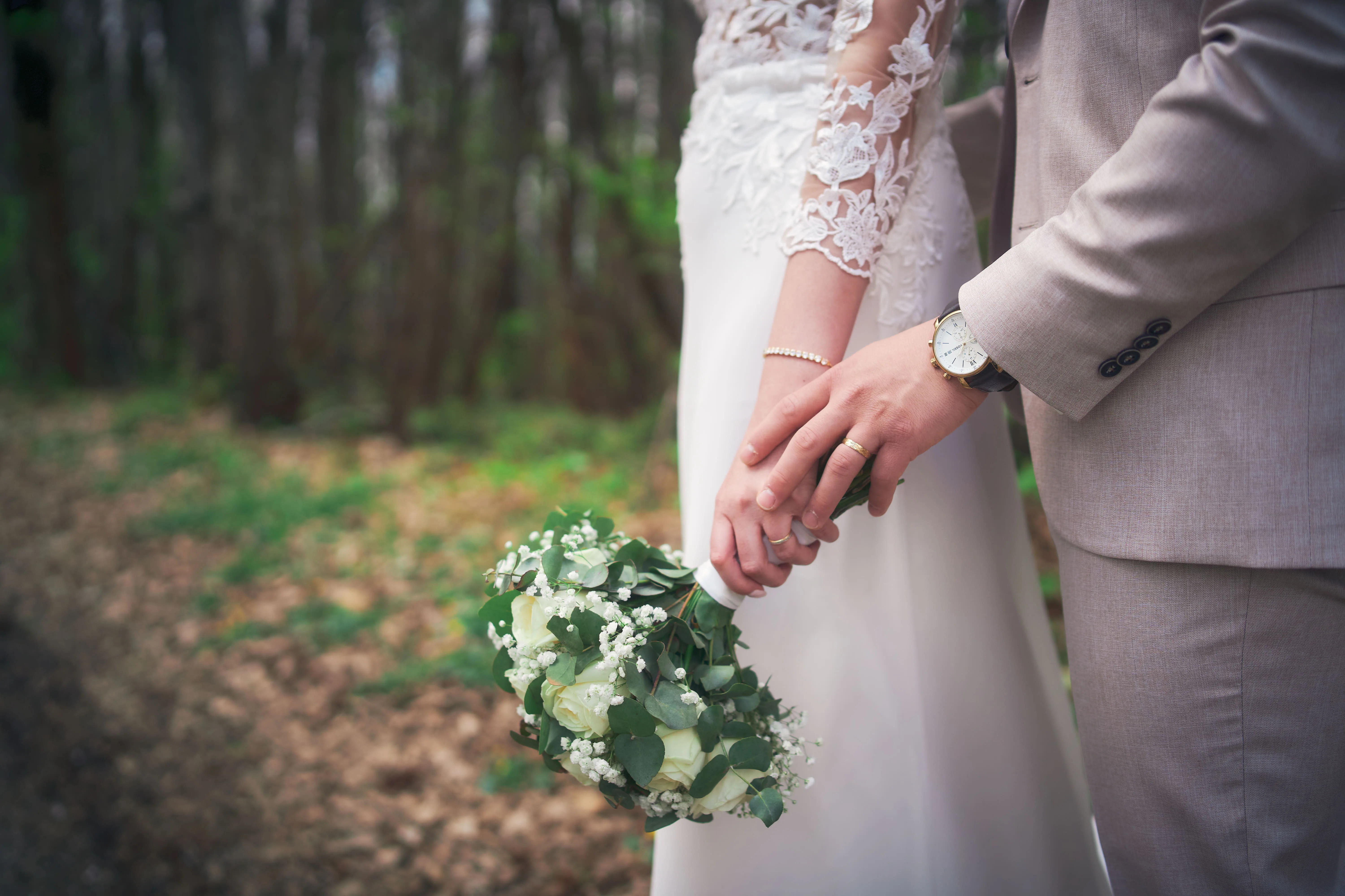 Les mains des mariés et le bouquet de Mélissa.
