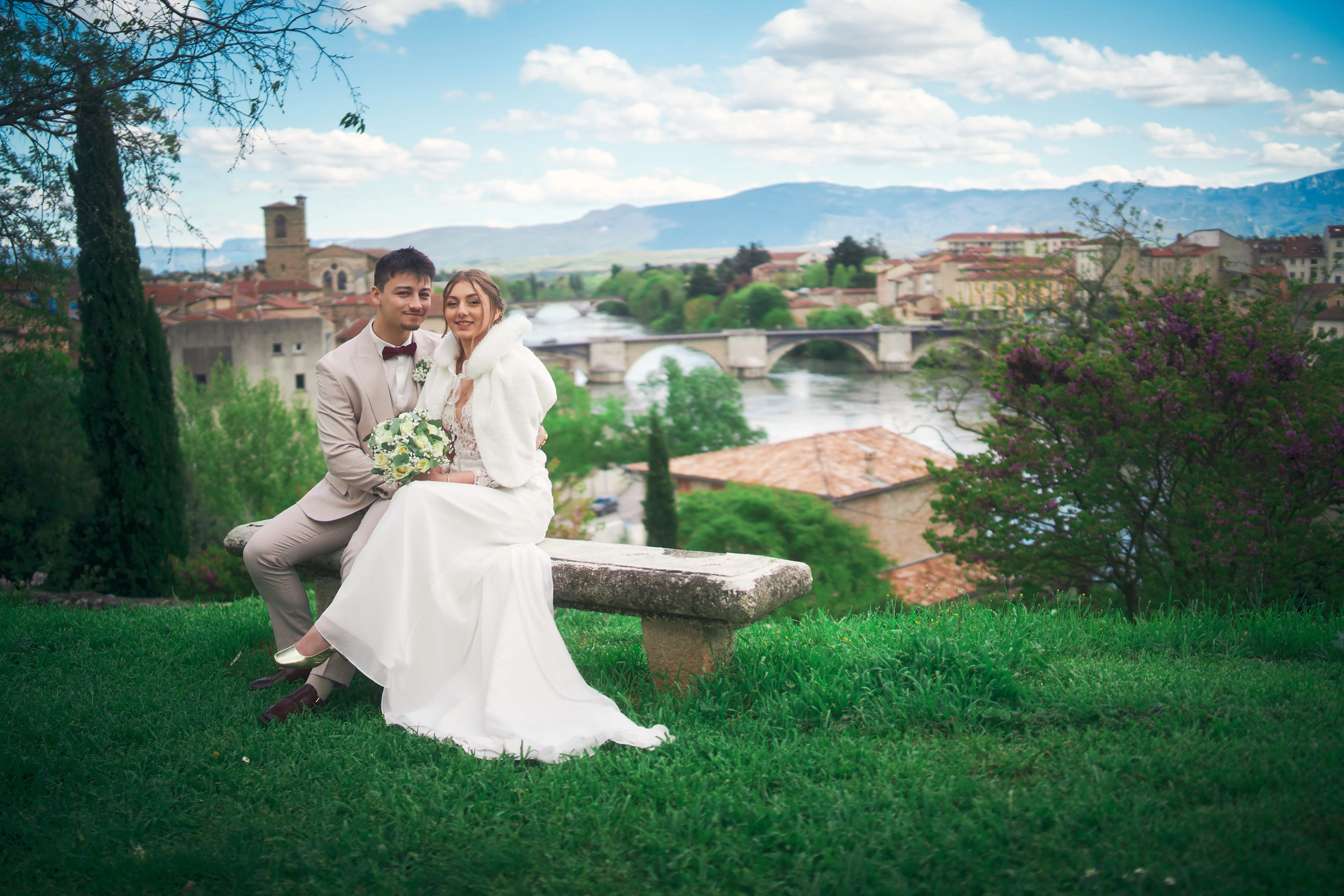Couple de mariés assis avec la ville en arrière-plan.