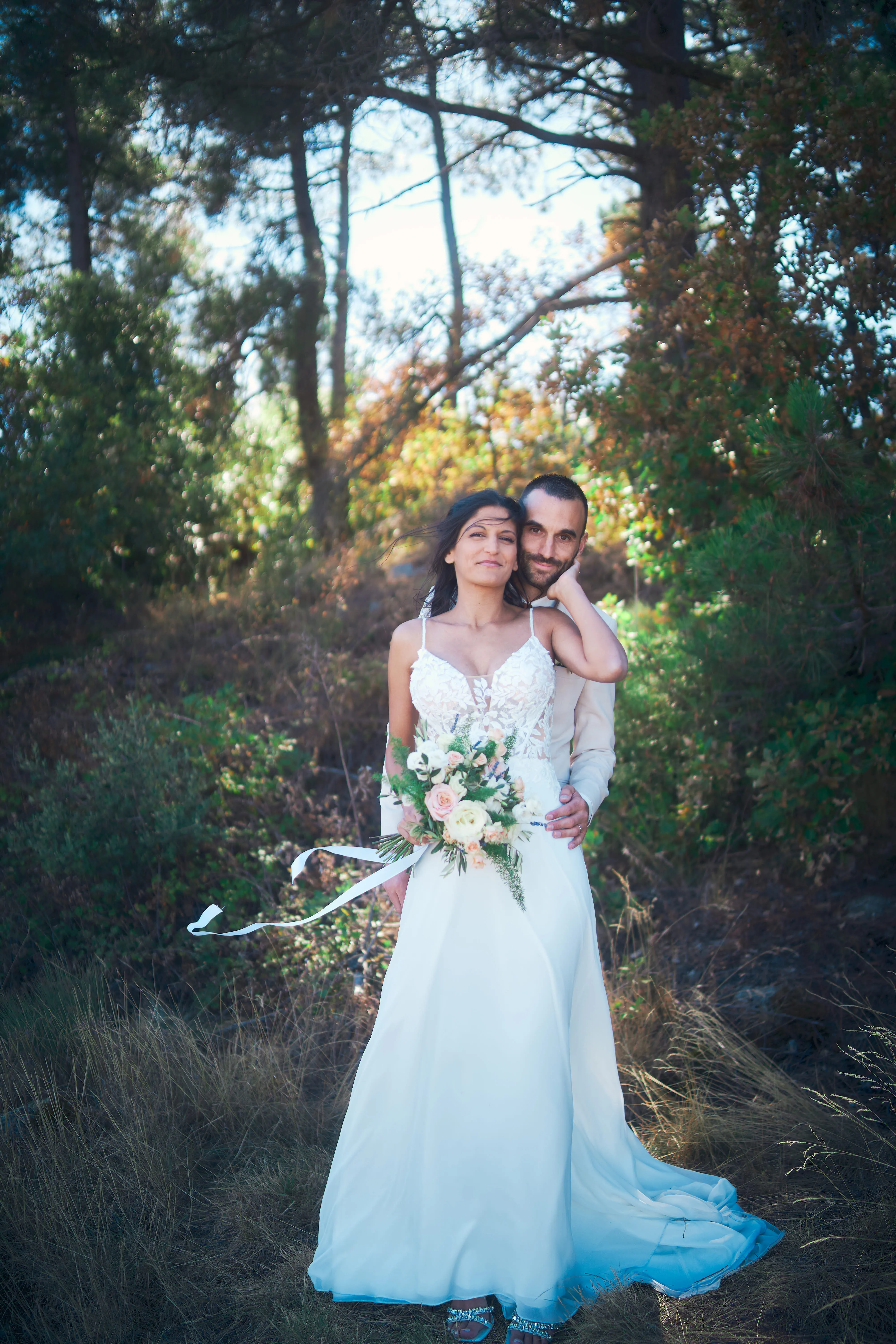 Mariée en robe blanche sous les arbres.