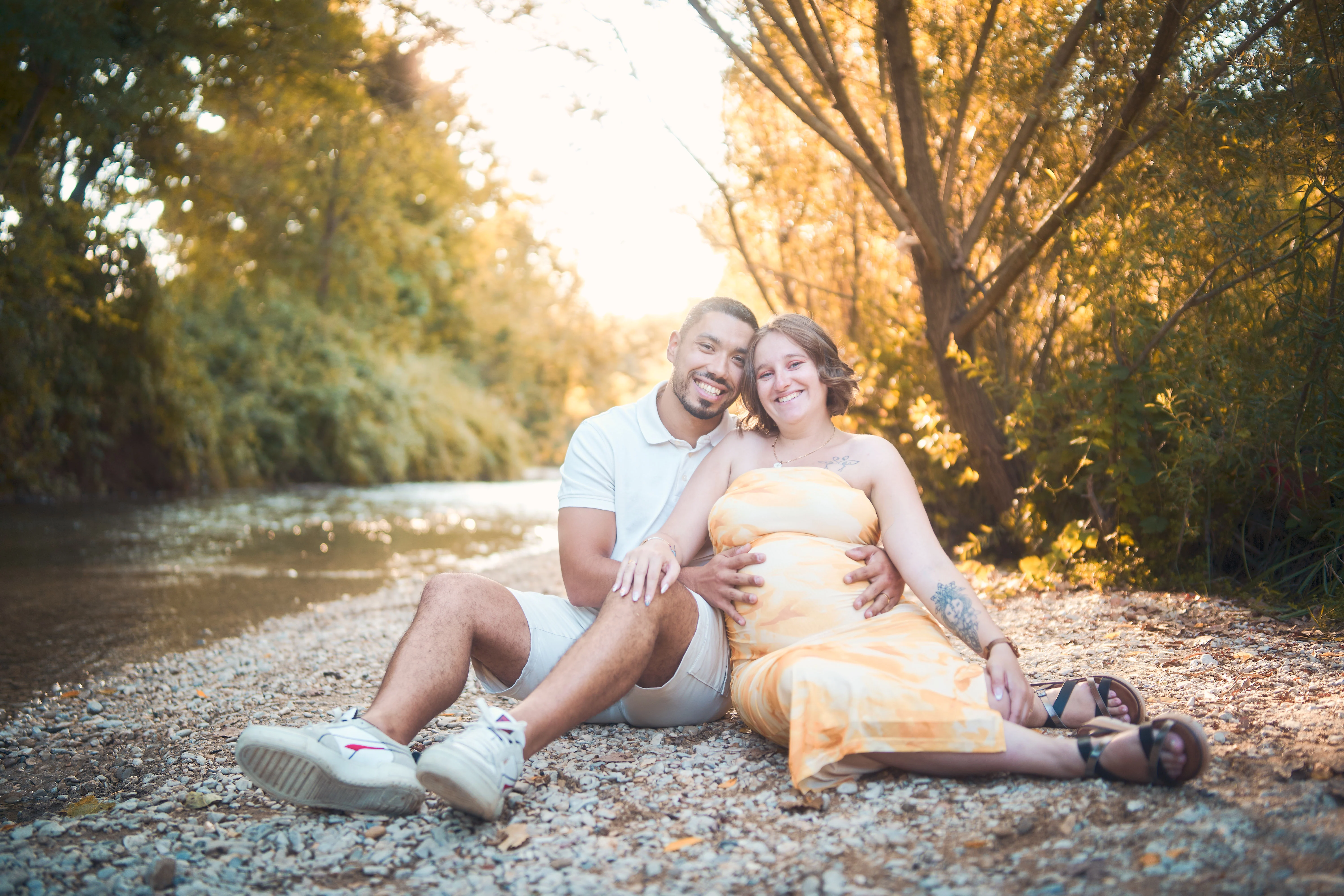 Femme enceinte en extérieur dans un paysage naturel.